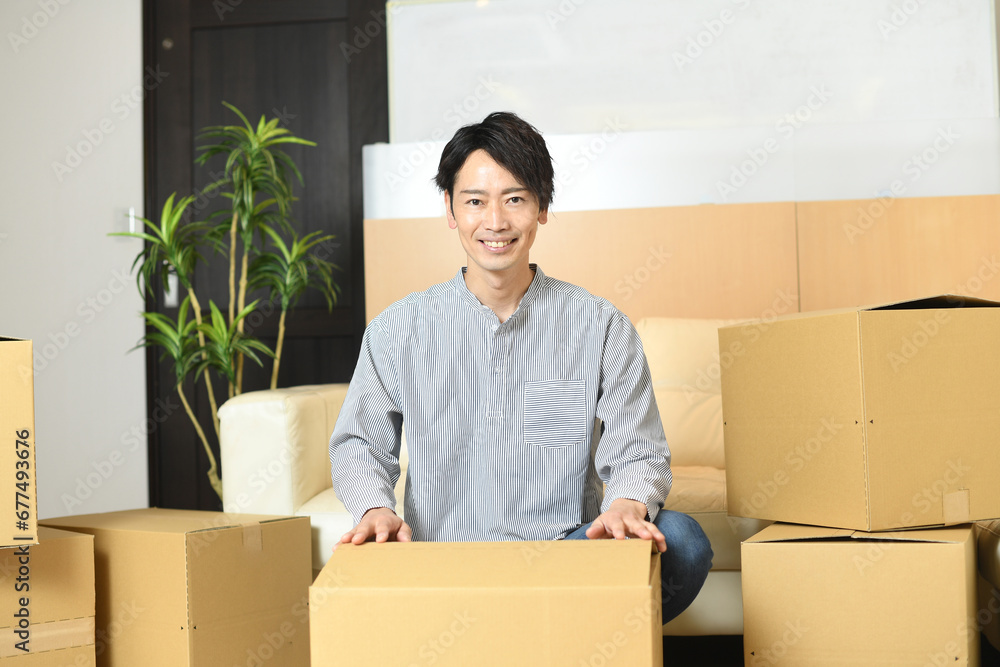大量の段ボール箱の前で片付けをする若いアジア人男性
大量の段ボール箱の前で片付けをする若いアジア人男性