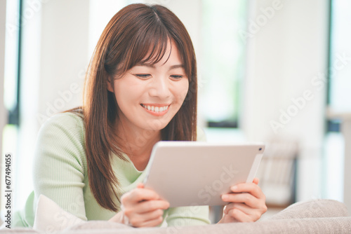 Free Download リビングでタブレットで動画を視聴する女性 - GFXLoad