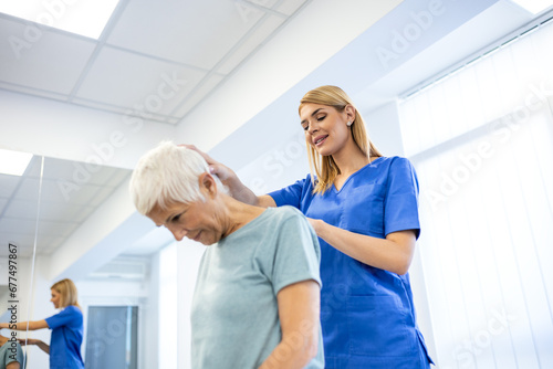 Licensed chiropractor or manual therapist doing neck stretch massage to relaxed female patient in clinic office. Young woman with whiplash or rheumatological problem getting professional doctor's help