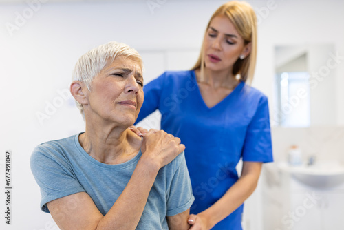 Wallpaper Mural Woman doctor osteopath in medical uniform fixing senior woman patients shoulder and back joints in manual therapy clinic during visit. Professional osteopath during work with patient concept Torontodigital.ca
