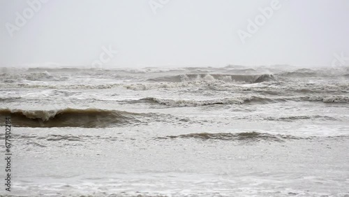 In slow motion dark, moody and threatening waves are whipped up by strong winds roll in before storm Ciarán makes landfall. photo