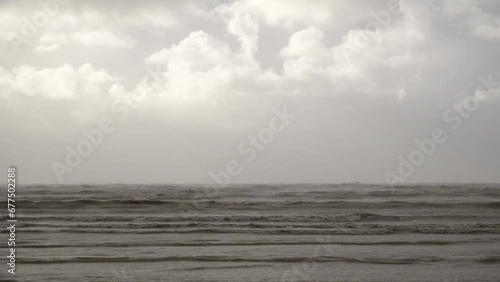 Thick and fast moving storm clouds pass over moody and threatening choppy waves whipped up by strong winds roll in before storm Ciarán makes landfall. photo