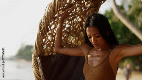 Woman Posing While Sitting On A Hanging Rattan Chair photo