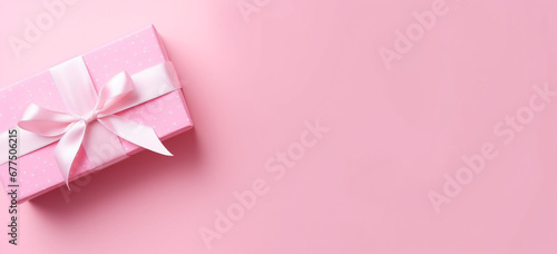 Gender reveal party concept  Top view photo of pink giftbox with white ribbon bow on isolated pastel pink background with copyspace