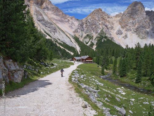 Tourist riding his Electric Mountain Bicycle on a Mountain Dirt Road in A Route Of The Alps, Italy photo