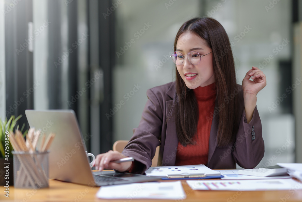 Asian businesswoman smiling using laptop computer at office. Confident Asia businesswoman sitting happily in the office. Asian businesswoman smiling using laptop computer at office. Confident Asia businesswoman sitting happily in the office.