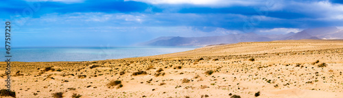 panorama of a deserted island overlooking the sea, mountains and sand dunes