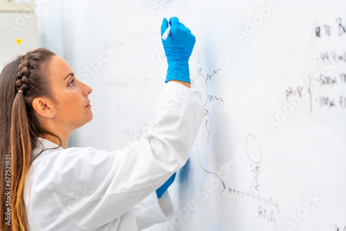 Scientist using a white board to write data