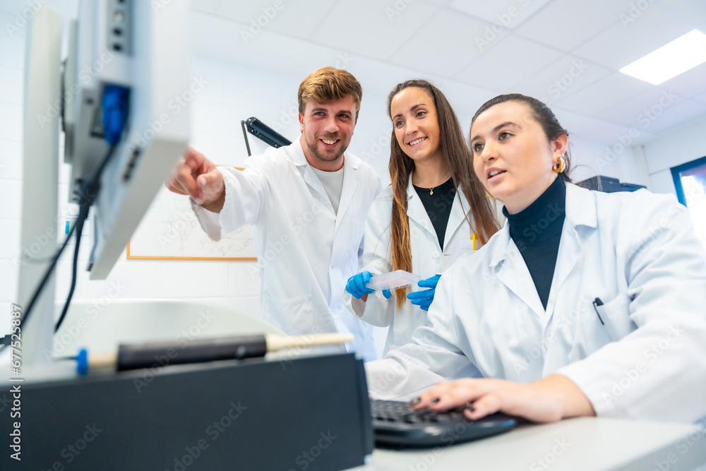 Happy doctors using computer in a research laboratory Happy doctors using computer in a research laboratory