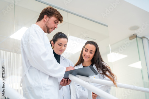 Three biologist talking while reading data on documents