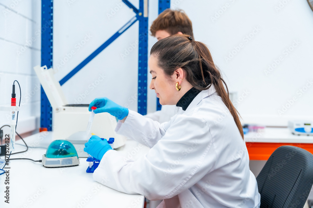 Young scientists working with samples sitting on a laboratory Young scientists working with samples sitting on a laboratory