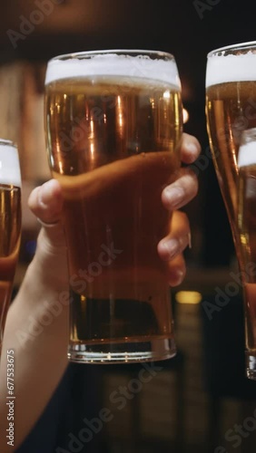 Multi-ethnic group of friends clinking glasses of beer at a restaurant.