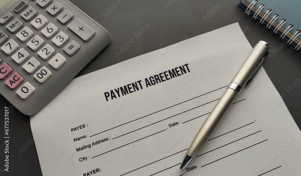 payment agreement form on the desk . Pen , calculator and notepad on the table payment agreement form on the desk . Pen , calculator and notepad on the table