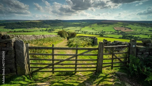 A timelapse of the sunlight passing across a gated path at Oakley Walls in the North York Moors National Park during late summer. A combine harvester works on the fields. photo