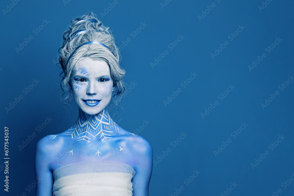 Mischievous cool cold woman with blue and white body art, carnival makeup and hairstyle