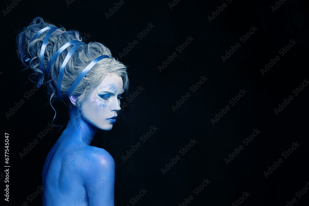 Fantastic cool cold woman with blue and white body art, carnival makeup and hairstyle on black background