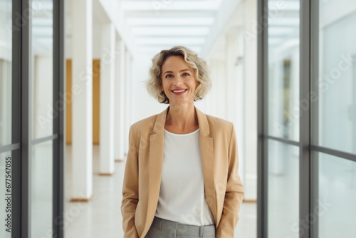 Portrait of a professional woman in a suit. Mature business woman standing in an office. Ceo corporate leader  female lawyer or leader manager wearing suit standing arms crossed in office.