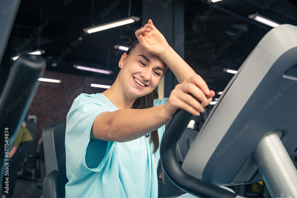 Fitness woman on bicycle doing cardio workout at gym. Fitness woman on bicycle doing cardio workout at gym.