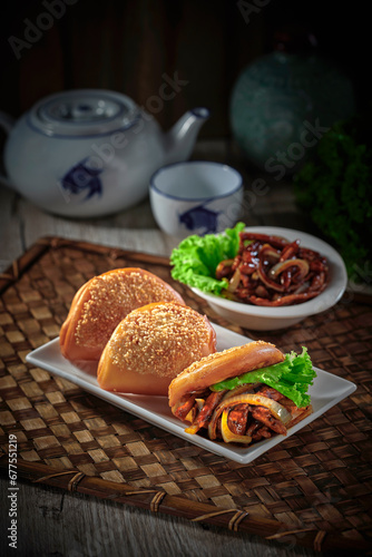 Obraz na płótnie traditional chinese Hong Kong dim sum steamed fresh hot burger man tou with gong bao chicken meat in bamboo basket on grey wood table background breakfast halal food menu for restaurant asian cafe w salonie