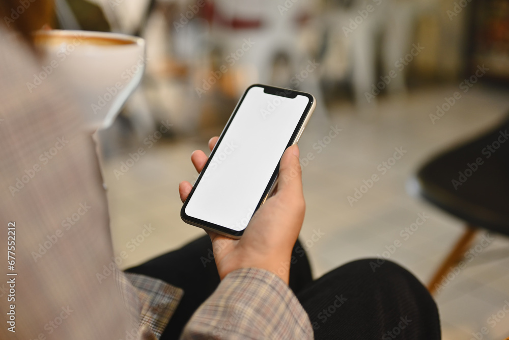 Woman in stylish suit drinking coffee and using mobile phone at cafe. Empty screen for your advertising text message Woman in stylish suit drinking coffee and using mobile phone at cafe. Empty screen for your advertising text message