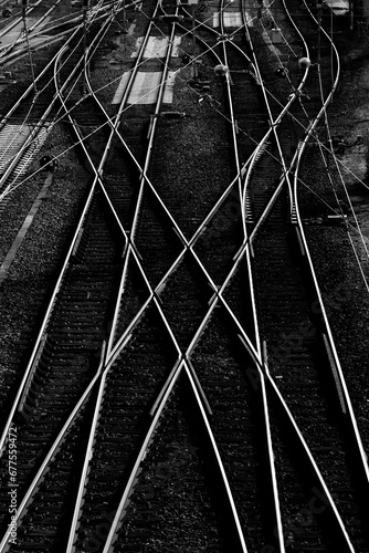 Railway tracks and switches at a big station forming geometrical and symmetrical structures and lines. Main station in Hagen Westphalia Germany. Black and white with high contrast, view from a bridge.