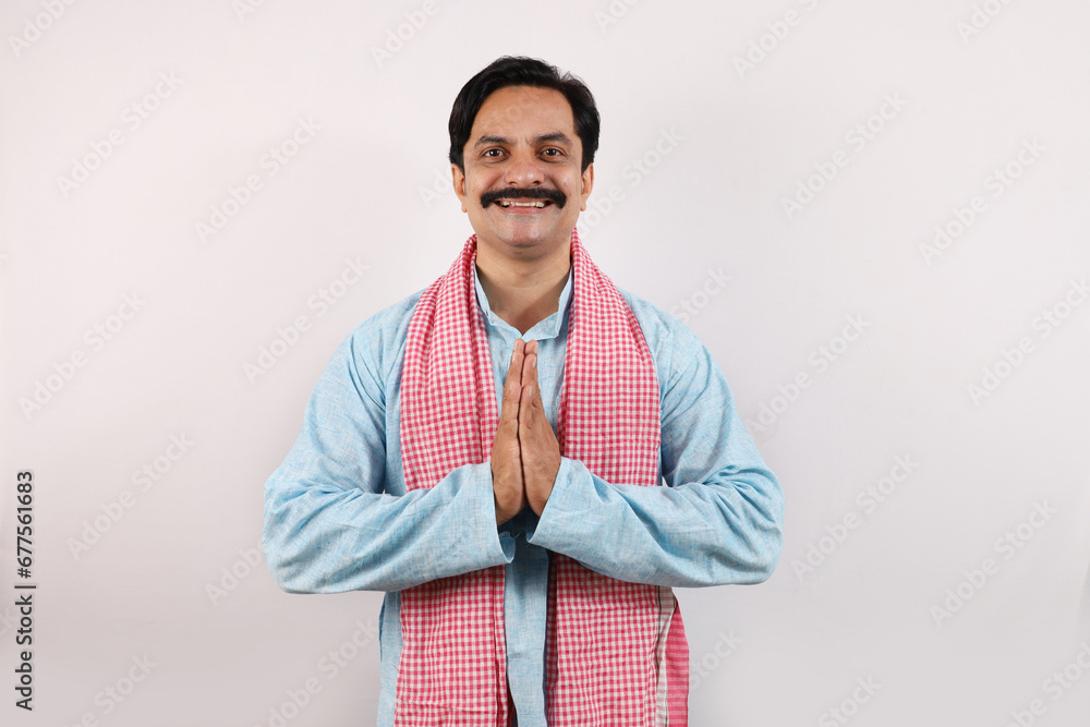 Happy rural Indian farmer standing in the white background, the passionate farmer full of enthusiasm shows sense of achievement and accomplishments, hands folded. Happy rural Indian farmer standing in the white background, the passionate farmer full of enthusiasm shows sense of achievement and accomplishments, hands folded.