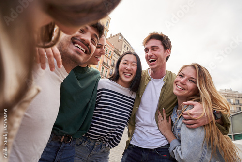 Multiracial young people team hugging together outdoor, diverse students and friends laughing. Smile happy carefree celebrating holidays. Concept unity, complicity and university community time. photo