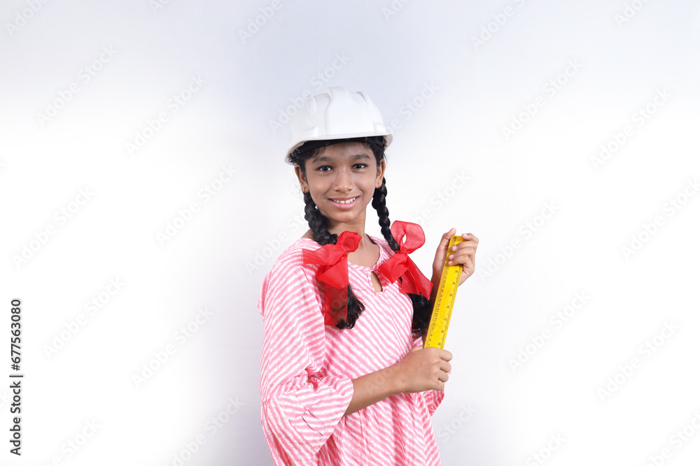 Portrait of Happy school kid as construction worker. Better and stable future concept. The school child is wearing construction manager helmet and ruler scale in hand. Portrait of Happy school kid as construction worker. Better and stable future concept. The school child is wearing construction manager helmet and ruler scale in hand.