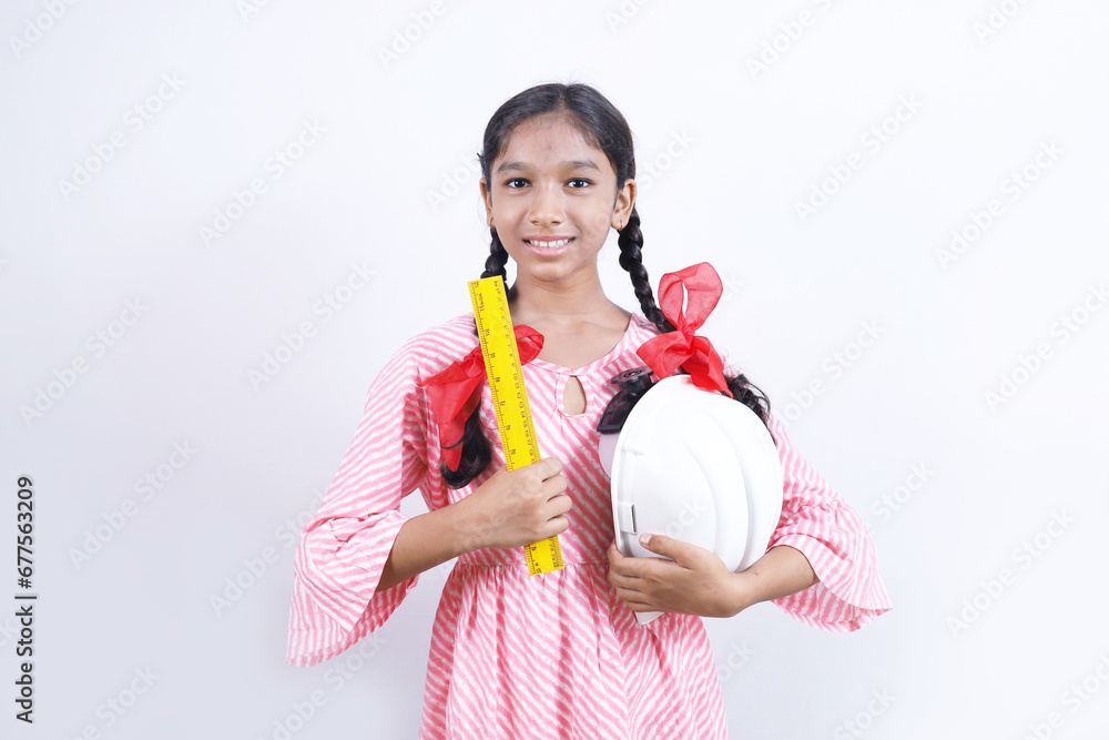 Portrait of Happy school kid as construction worker. Better and stable future concept. The school child is wearing construction manager helmet and ruler scale in hand. Portrait of Happy school kid as construction worker. Better and stable future concept. The school child is wearing construction manager helmet and ruler scale in hand.