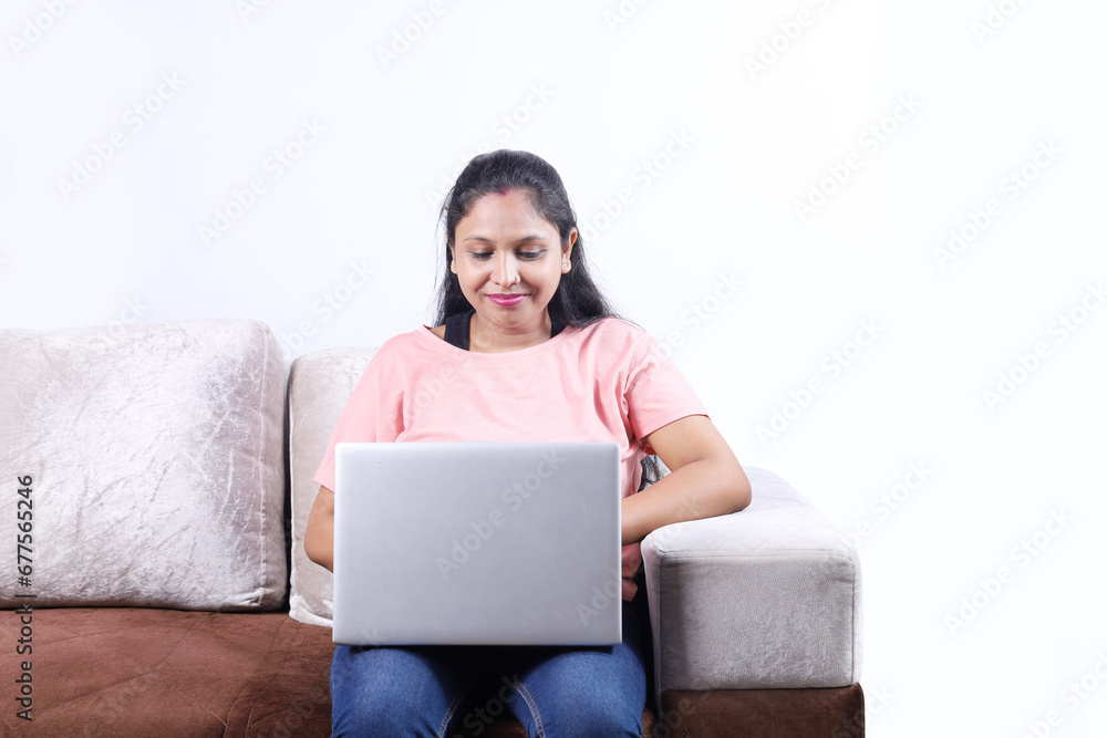 Happy Indian woman surfing laptop having pleasant time together joyfully. lady is looking into the laptop. Happy Indian woman surfing laptop having pleasant time together joyfully. lady is looking into the laptop.
