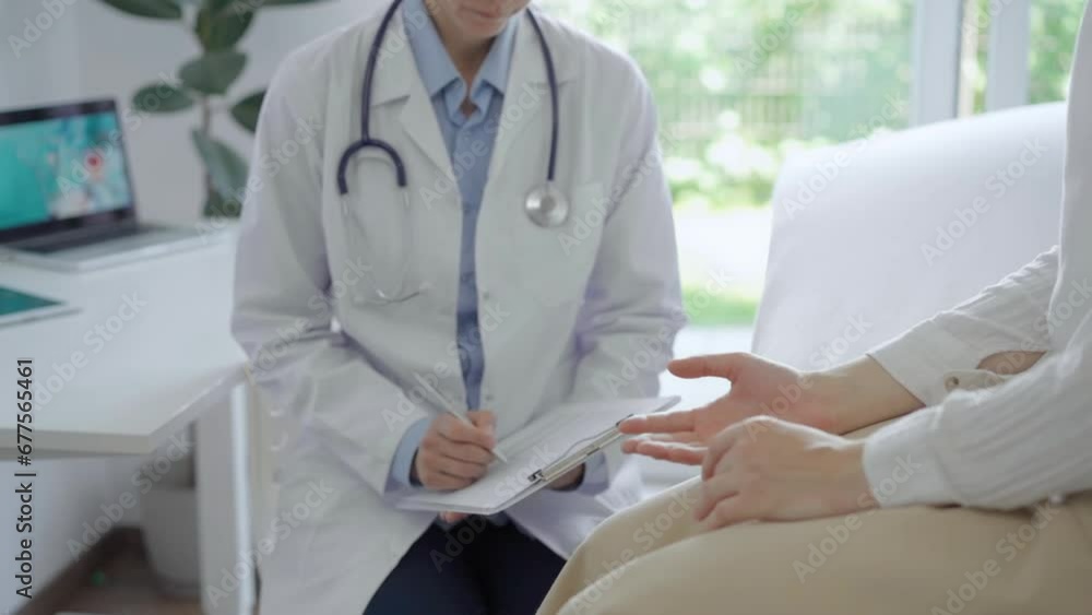 Doctor and patient are in the clinic. Young woman is sitting on sofa and talking to a pediatrician who is using a clipboard for making medical notes. Medicine, healthcare concepts Doctor and patient are in the clinic. Young woman is sitting on sofa and talking to a pediatrician who is using a clipboard for making medical notes. Medicine, healthcare concepts