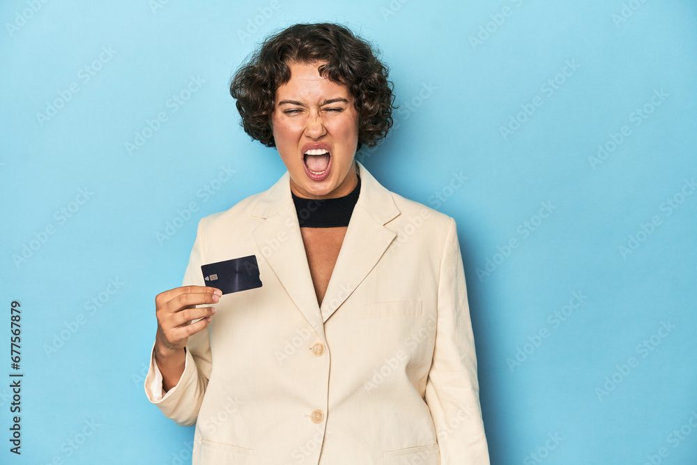 Young woman with credit card, elegant white blazer screaming very angry and aggressive. Young woman with credit card, elegant white blazer screaming very angry and aggressive.