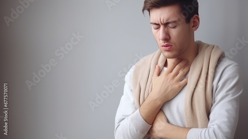 The young man has his hand on his chest and is in pain. Symptoms of a cold or flu. Chest pain, cough photo