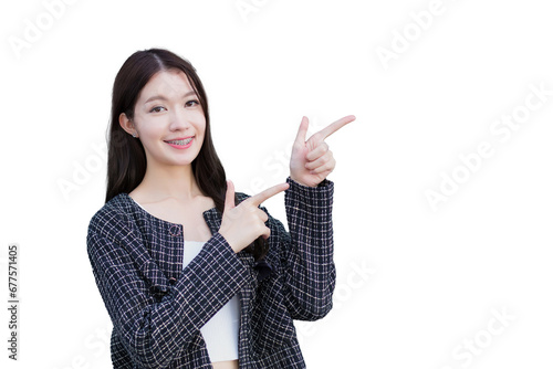 Professional Asian working woman who wears black suit with braces on teeth is pointing hand to present something while isolated on white background.