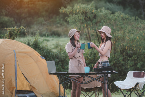 Happy woman freelancer traveller working online using laptop ,take photo and drink a cup coffee or tea enjoying the beautiful camping tent landscape with mountain is holiday relaxed lifestyle concept.