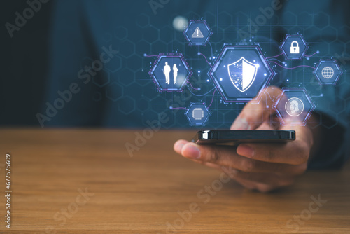 Businessman using mobile phone with cyber security icons screen. Digital information technology and  cyber security concept.