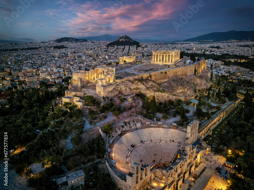 Aerial view of illuminated, ancient ruins at the Acropolis of Athens, Greece, and Odeon of Herode theatre during dusk photo