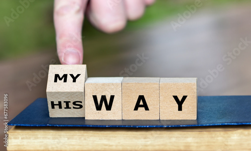 Hand turns dice and changes the expression 'his way' to 'my way'. photo