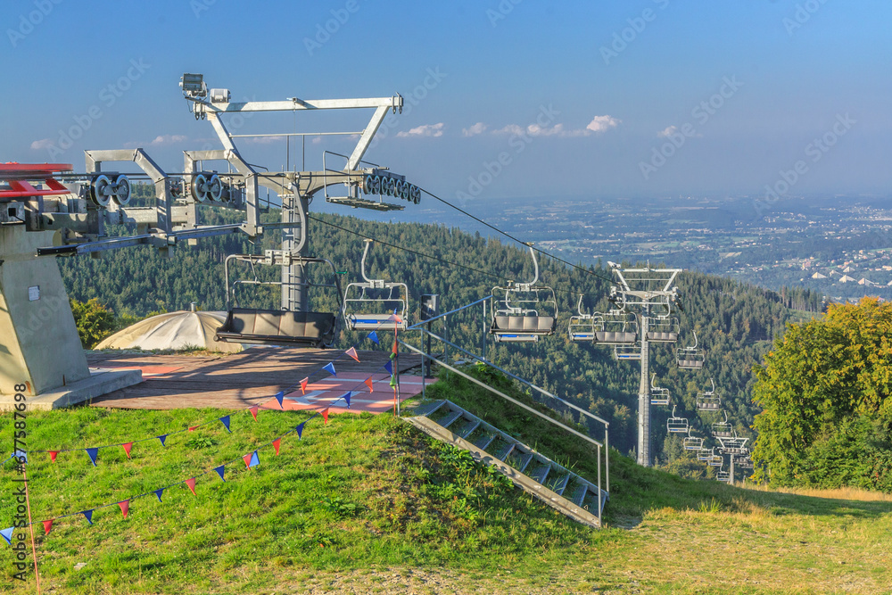 The upper station of the chairlift to Mała Czantoria in the Silesian Beskids (Poland) on a sunny summer day. In the distance, the buildings of Ustroń.