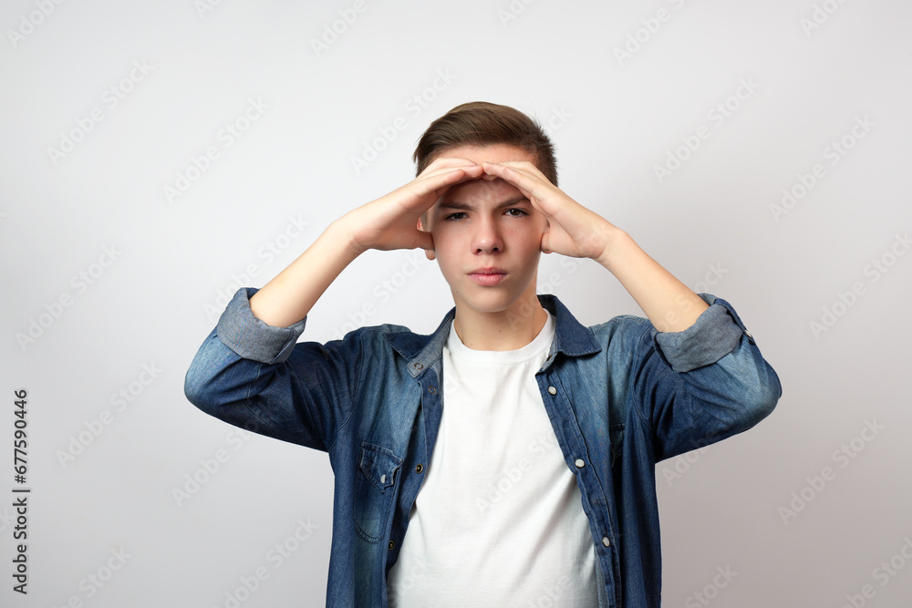 Teenage boy holding hands on his forehead and looking far away to the future, Teenage boy holding hands on his forehead and looking far away to the future,