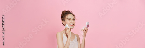 Beautiful model putting makeup powder with cosmetic cushion on her face. photo