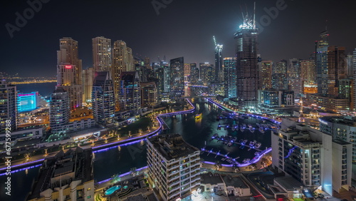 Panorama showing Dubai Marina skyscrapers and JBR district with luxury buildings and resorts aerial night timelapse