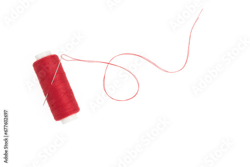 Spool of red thread with a needle isolated on white