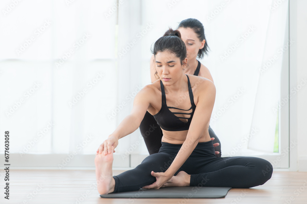 Yoga instructor assisting pupils in doing yoga poses in the studio, Yoga class concept Yoga instructor assisting pupils in doing yoga poses in the studio, Yoga class concept