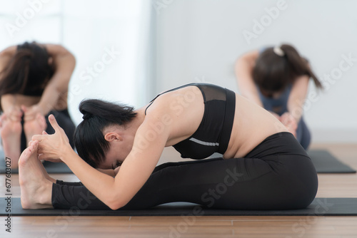 Group of people practicing yoga in a studio. Yoga class concept.