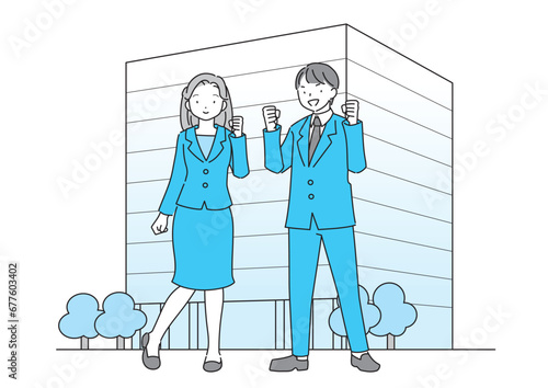 社屋の前に立つスーツを着た元気な若い男女