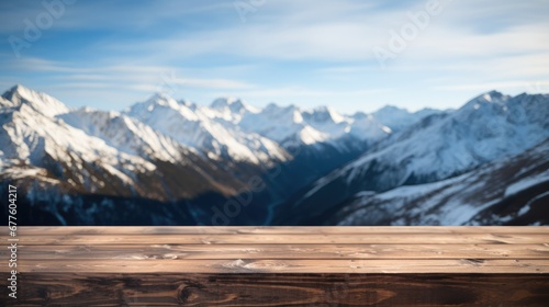 Close up of a top wooden table with snowy mountains background. © visoot