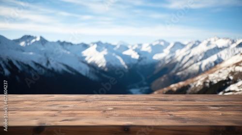 Close up of a top wooden table with snowy mountains background.