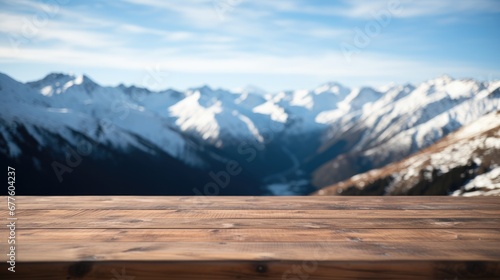 Close up of a top wooden table with snowy mountains background. © visoot