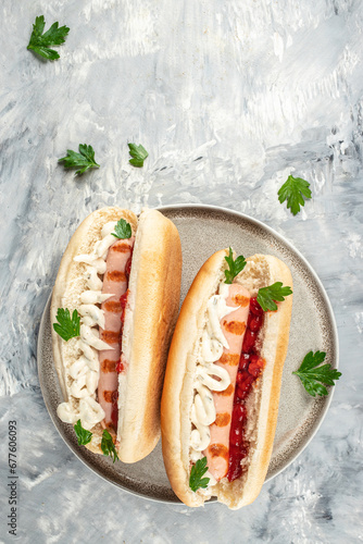 Hot dog with sausage in a bun with sauces on a light background, Fast food menu for kids, vertical image. top view. copy space for text